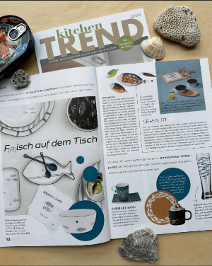 aufgeschlagene Kitchentrend mit dem Artikel F(r)isch auf dem Tisch umringt von
